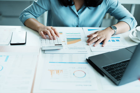 financial, Planning, Marketing and Accounting, portrait of Asian employee checking financial statements using documents and calculators at work..の写真素材