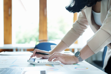 financial, Planning, Marketing and Accounting, portrait of Asian woman Economist using calculator to calculate investment documents with partners on profit taking to compete with other companies.の写真素材