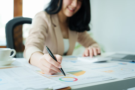 financial, Planning, Marketing and Accounting, portrait of Asian woman Economist using calculator to calculate investment documents with partners on profit taking to compete with other companies.の写真素材