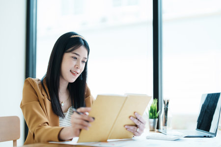 financial, Planning, Marketing and Accounting, portrait of Asian employee checking financial statements using Notebook at work..の写真素材