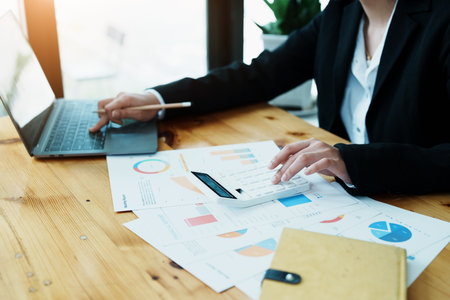 Accountants, Asian auditors are using calculators and computers to review annual tax budgets to submit information to the IRSの写真素材