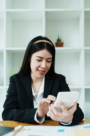 financial, Planning, Marketing and Accounting, portrait of Asian employee checking financial statements using documents and calculators at work..の写真素材