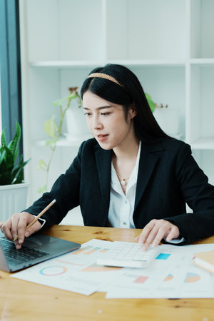 Accountants, Asian auditors are using calculators and computers to review annual tax budgets to submit information to the IRSの写真素材