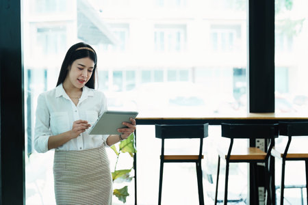 Portrait of a beautiful Asian teenage girl using a tablet computer.の写真素材