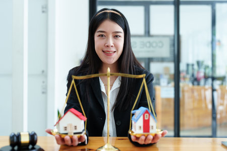 Portrait of a Beautiful Asian Lawyer Shows Housing Justice.の写真素材
