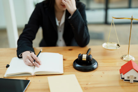 Portrait of a beautiful Asian lawyer studying a lawsuit for a client before going to court.の写真素材