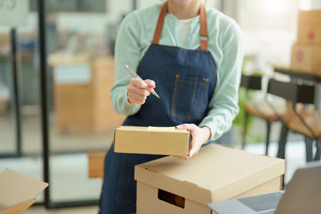 A portrait of a small startup, and SME owner, an Asian female entrepreneur, is writing down...
