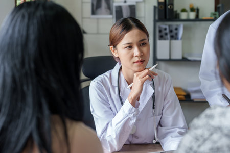 Portrait of a doctor advising clients on health issues holding a tablet to work and talking to patients who come to treatment.の写真素材
