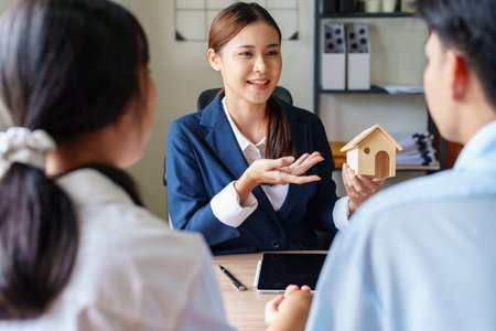 Portrait of a real estate agent or bank officer, the lending department quotes the interest on the loan to the customer to assess the risk of investing in a home.の写真素材