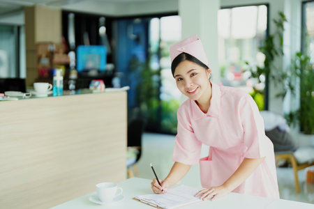 Portrait of a young Asian nurse looking at patient documents to analyze symptoms before sending them to the doctor for examination.の写真素材