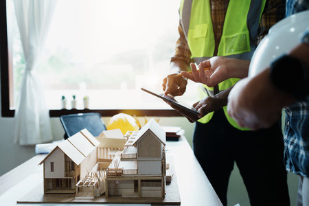 Engineers are consulting the team to design an architectural structure for clients with blueprints...