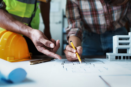 Engineers are consulting the team to design an architectural structure for clients with blueprints...