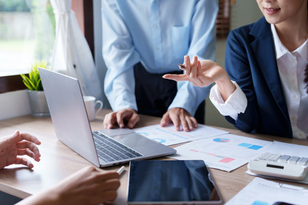 Business groups use documents and market analysis computers to formulate investment strategies and assess risks of competing with other companies.の写真素材