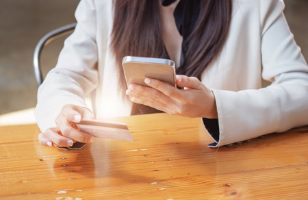 Asian young woman using a mobile phone and credit card for online shopping.の写真素材