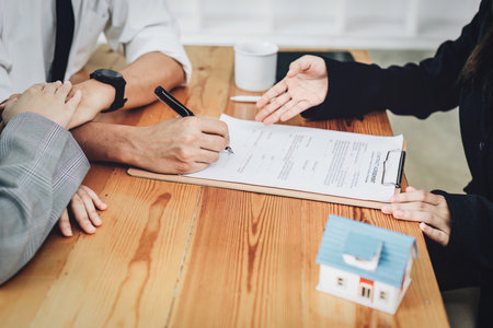 A spouse entering a home contract is reading the terms of the loan interest agreement that the bank...