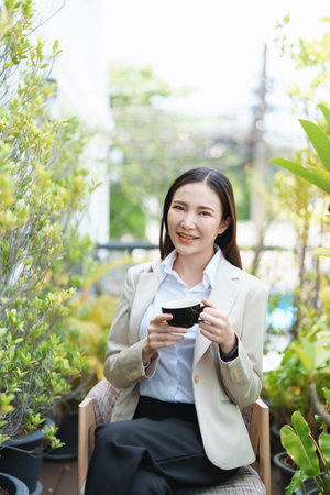 business woman sitting and drinking coffee and smiling happily.の写真素材