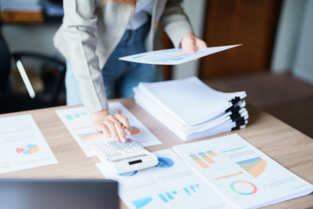 Accountants, Asian auditors are using calculators and computers to review annual tax budgets to...
