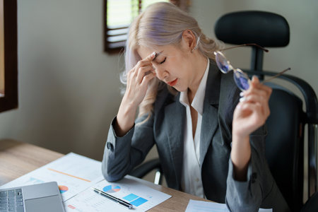 Portrait of sme business owner, woman using computer and financial statements Anxious expression on expanding the market to increase the ability to invest in business.の写真素材