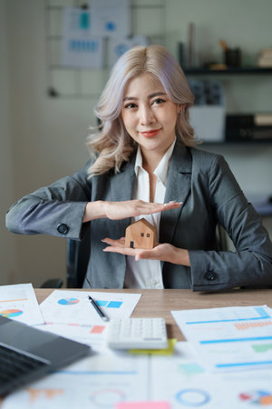 portrait of an asian man, Agent, buy and sell land, property tax, show the concept of protecting the house to insure the risk of damage to the home.の写真素材