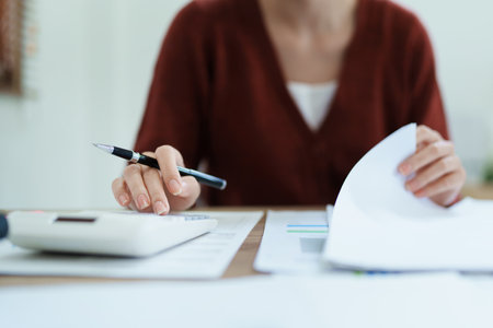 financial, Planning, Marketing and Accounting, portrait of Asian employee checking financial statements using documents and calculators at work..の写真素材