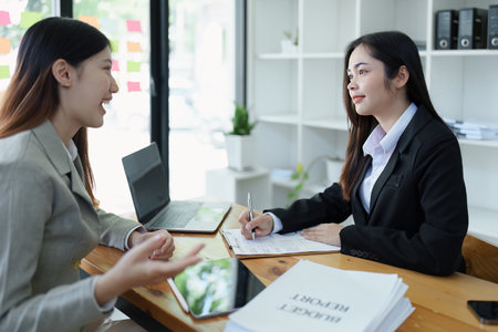 Financial analysts analyzing business reports on planned investment projects during corporate meeting discussions showcase successful teamwork with marketing plan, computers and calculators to work.の写真素材