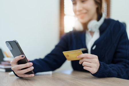 Online Shopping and Internet Payments, Asian man are using their credit card and mobile phone to shop online or conduct errands in the digital worldの写真素材