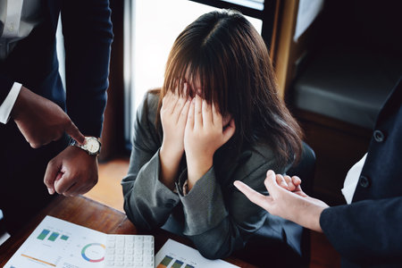 Portrait of a female worker showing failure at work and being reprimanded by a colleague.の写真素材