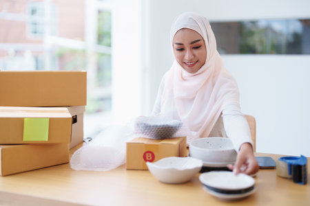 Beautiful Muslim woman selling online at home, business owner, business sme concepts.の写真素材