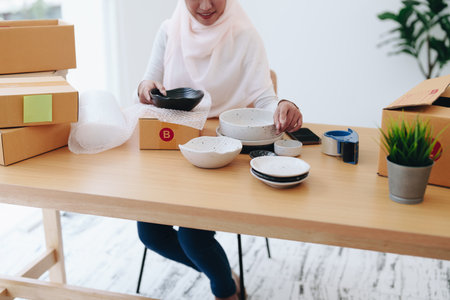 Beautiful Muslim woman selling online at home, business owner, business sme concepts.の写真素材