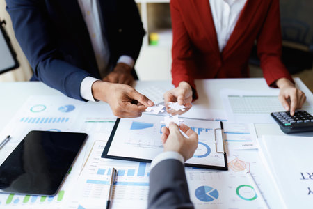 Business people with jigsaw puzzle pieces in office, Successful teamwork and partnership concept