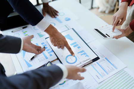 Team business adviser meeting to analyze and discuss the situation on the financial report n the meeting room with using documents, calculator, computer laptop in workの写真素材