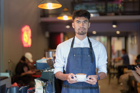 Asian male barista making coffee for customers.