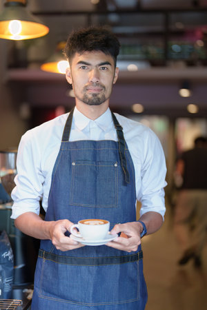 Asian male barista making coffee for customers.の写真素材