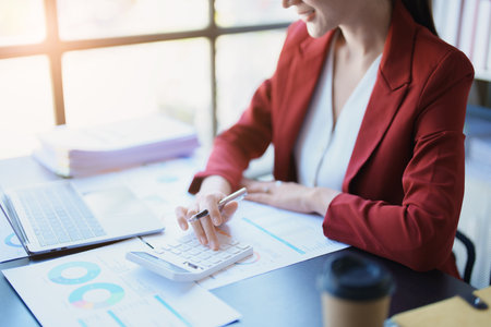 Accountants, Asian auditors are using calculators and computers to review annual tax budgets to submit information to the IRSの写真素材
