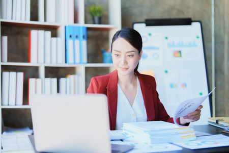 financial, Planning, Marketing and Accounting, portrait of Asian employee checking financial statements using documents and calculators at work..の写真素材