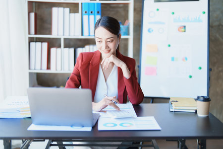 financial, Planning, Marketing and Accounting, portrait of Asian employee checking financial statements using documents and calculators at work..の写真素材