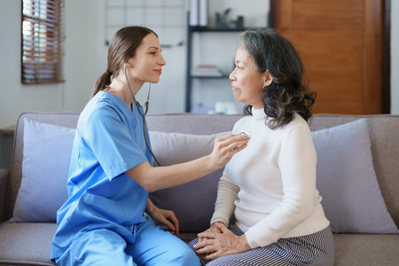 Portrait of a female doctor using a stethoscope to check the pulse of an elderly patientの写真素材