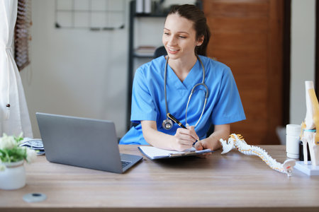 Portrait of a female doctor Center of Excellence from Orthopedic Center are using computers and documents to analyze the patients condition before treatmentの写真素材