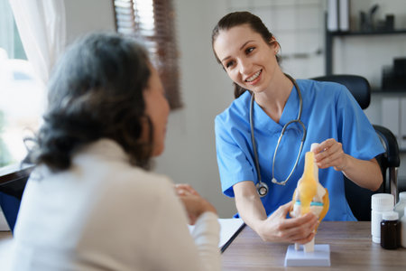 Portrait of a female doctor talking to an elderly patient about osteoarthritisの写真素材