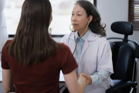 Portrait of a female doctor using a stethoscope to check the pulse of an elderly patientの写真素材