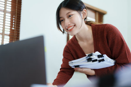 financial, Planning, Marketing and Accounting, portrait of Asian employee checking financial statements using documents and computer at work..の写真素材