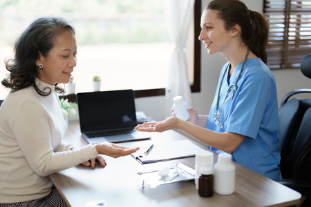 Portrait of a female doctor giving medicine to an elderly patientの写真素材