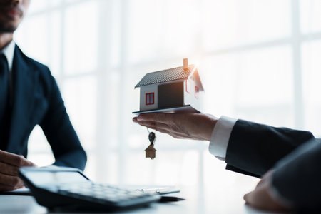 Real estate company to buy houses and land are delivering keys and houses to customers after agreeing to make a home purchase agreement and make a loan agreementの写真素材