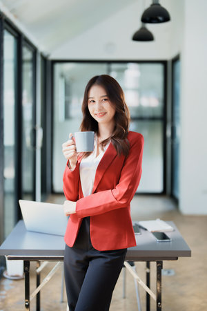 business woman sitting and drinking coffee and smiling happily.の写真素材