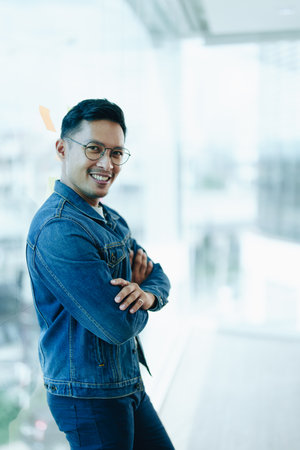 Asian male business owner smiling in front, showing his success in business investment.の写真素材