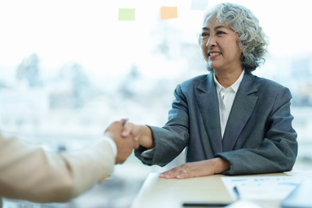 Asian entrepreneurs handshakes to congratulate the agreement between the two companies to enhance investment and financial strength. deal concept.の写真素材