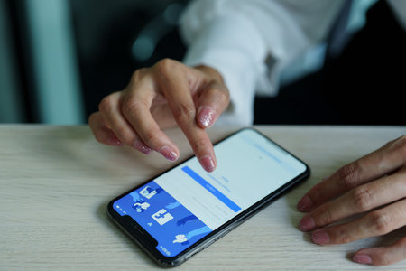 Chiang Mai Thailand. Sep 08, 2022. Woman holds smart phone with facebook application on the screen. facebook is a photo-sharing app for smartphonesのeditorial素材