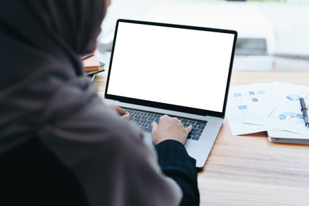 A beautiful Muslim woman uses a white computer screen ready to put text and illustrations on empty spaces.の写真素材
