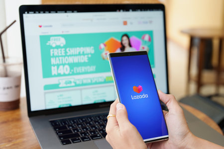 CHIANG MAI, THAILAND, Jul 09 , 2022 - woman holding a mobile phone to use lazada app to shop online.のeditorial素材