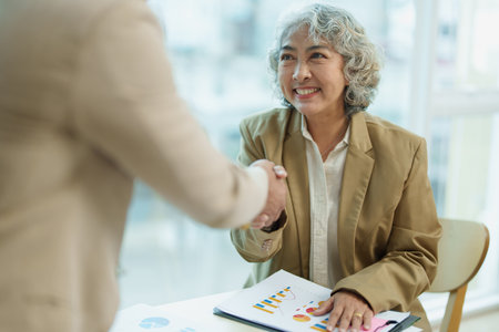 Asian entrepreneurs handshakes to congratulate the agreement between the two companies to enhance investment and financial strength. deal concept.の写真素材